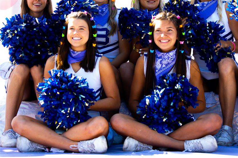 Two cheerleaders smile